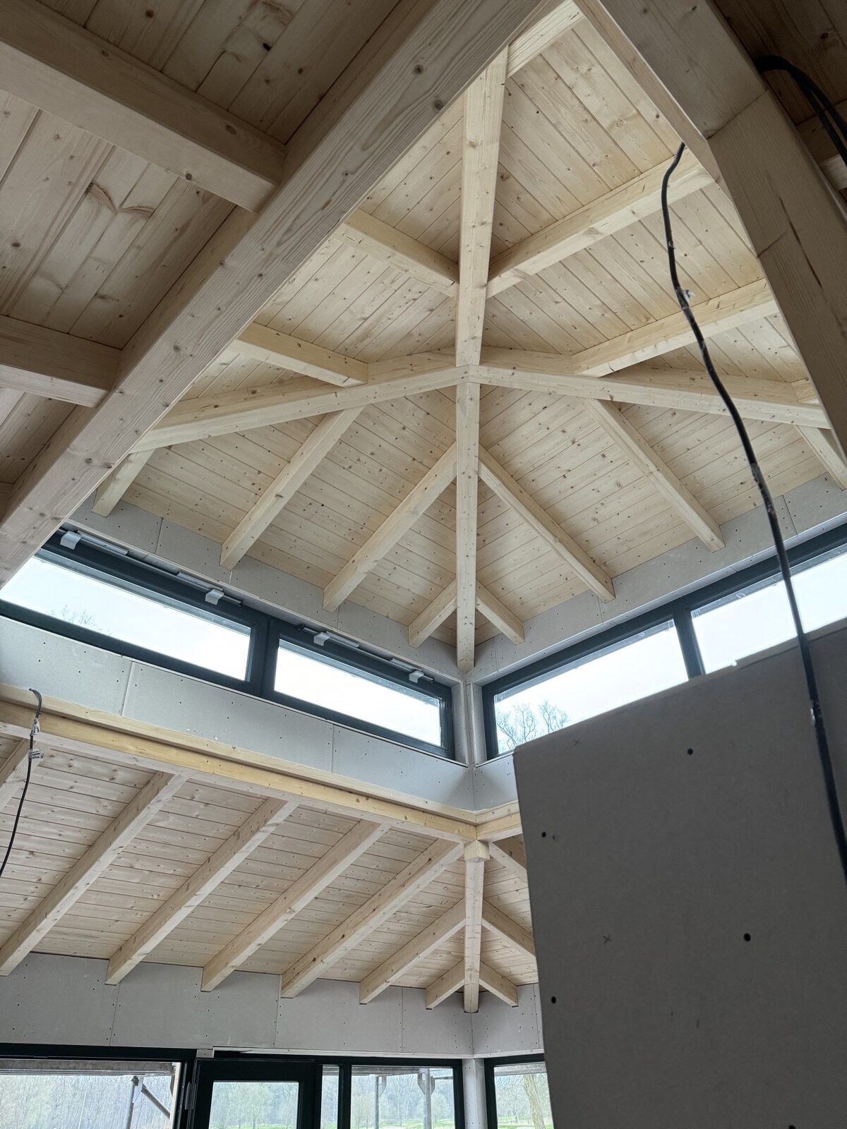 Offene Dachstuhlkonstruktion in Holzrahmenbauweise von Eggers Holzbau, Blick von innen auf die sichtbare Holzkonstruktion